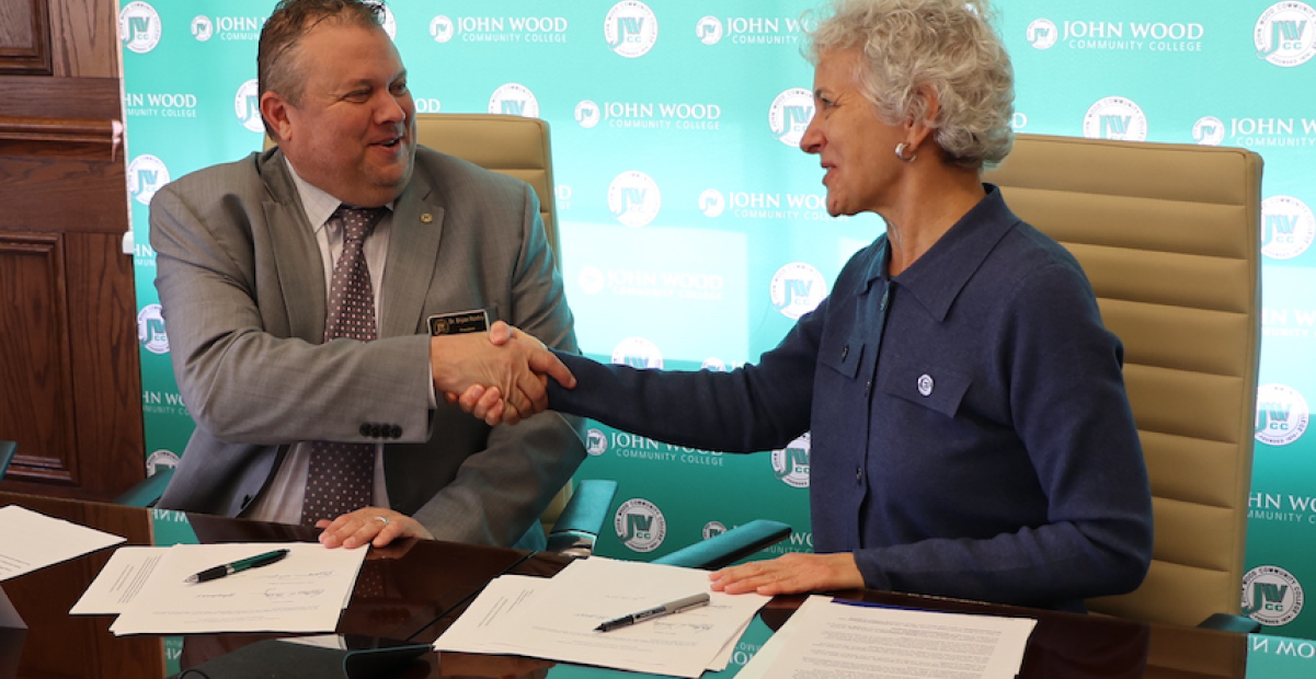 Dr. Bryan Renfro, JWCC (JWCC) President and Dr. Barbara Farley, Illinois College (Illinois College) President, shake hands after signing agreements.