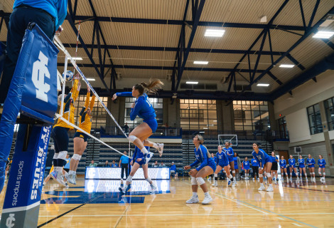 Lady Blues volleyball player spiking the ball 